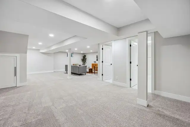 Finished basement in Upper Arlington, OH with open living area, recessed lighting, new carpet and white utility room doors